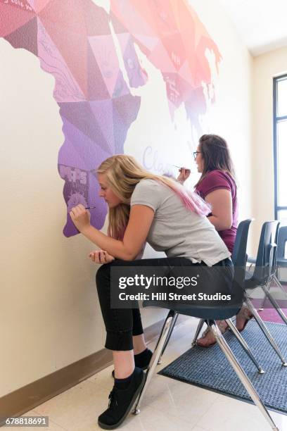 girls painting mural of map on school wall - young artists unite stock pictures, royalty-free photos & images