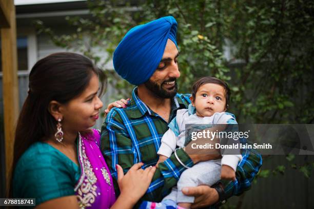 couple admiring baby son - sikhism stock-fotos und bilder