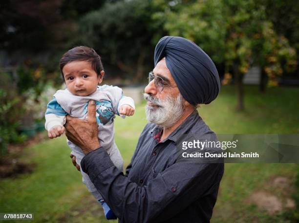 indian grandfather holding baby grandson - turban family stock pictures, royalty-free photos & images