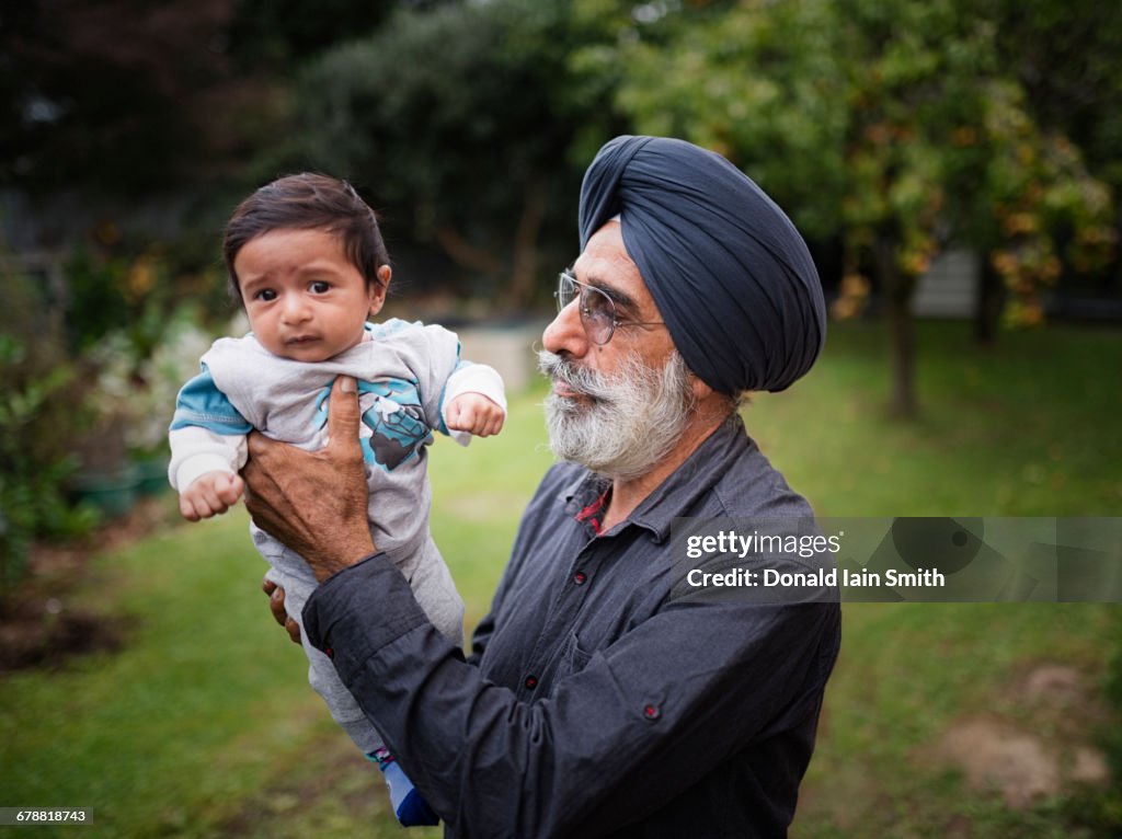 Indian grandfather holding baby grandson