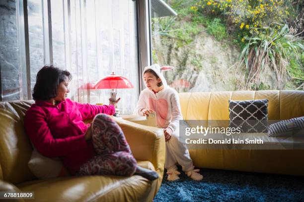 Mother showing cell phone to daughter wearing rabbit costume