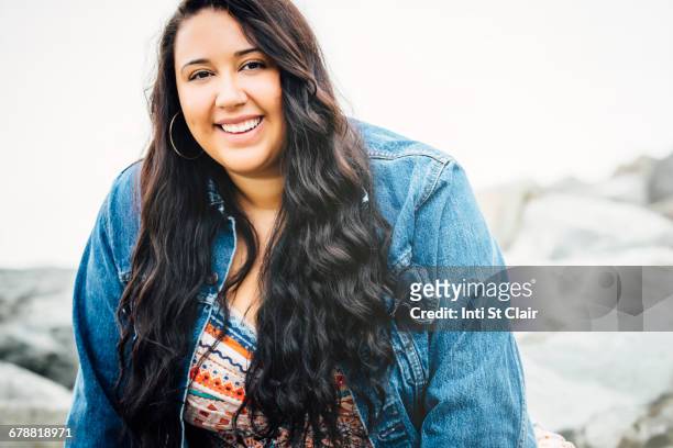 Smiling Mixed Race woman near ocean