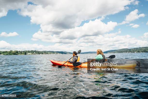 man and woman paddling kayak - kayak ストックフォトと画像