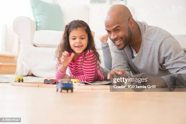 father and daughter playing with toy cars on floor - toy truck stock pictures, royalty-free photos & images