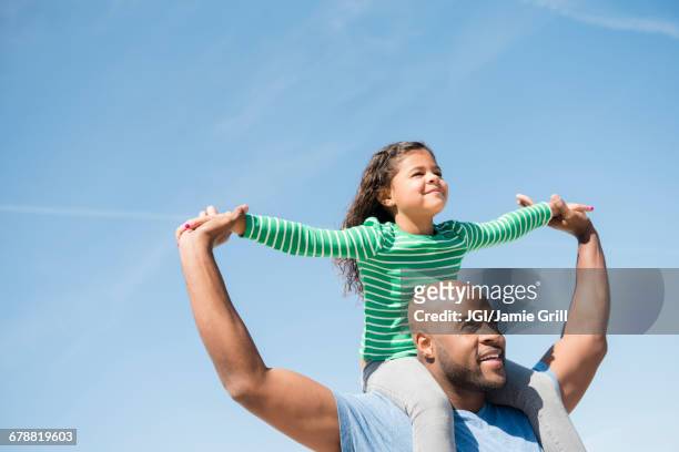 father carrying daughter on shoulders - carrying on shoulders stock pictures, royalty-free photos & images