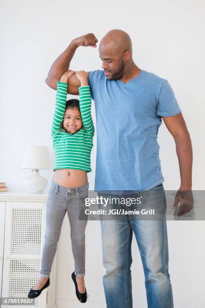 father lifting daughter using biceps - bíceps fotografías e imágenes de stock