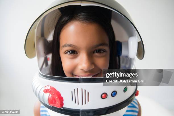 mixed race girl wearing astronaut helmet - astronaut helmet stock-fotos und bilder