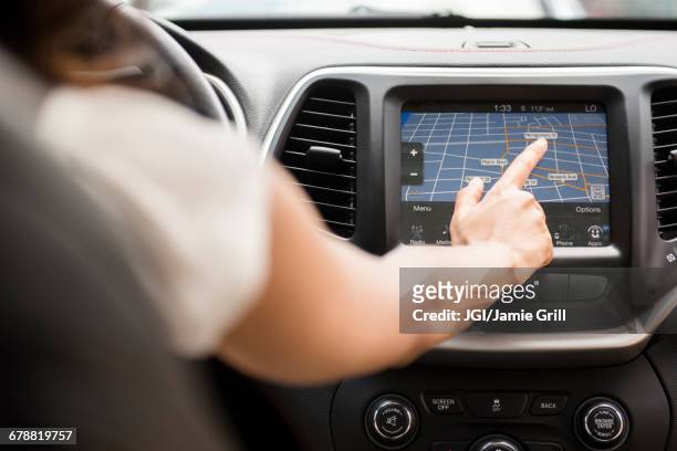 mixed race woman using touch screen navigation map in car - navigatore foto e immagini stock