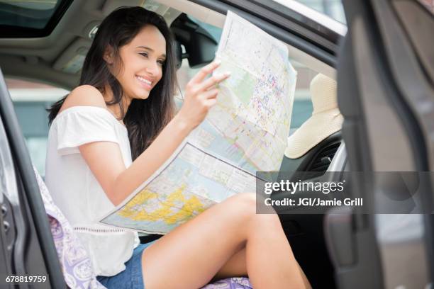 mixed race woman sitting in car reading map - vacation planning stock pictures, royalty-free photos & images