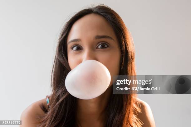 mixed race woman blowing bubble with gum - bubble gum bubble stock pictures, royalty-free photos & images