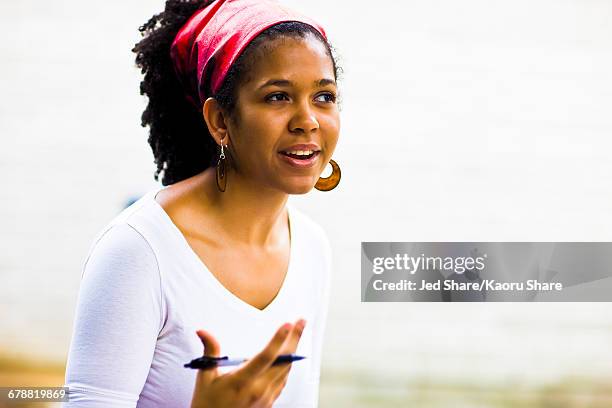 mixed race woman gesturing with pen - listening skills stock pictures, royalty-free photos & images