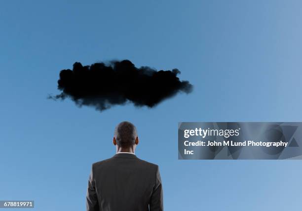 dark cloud over mixed race businessman - pessimisme stock pictures, royalty-free photos & images