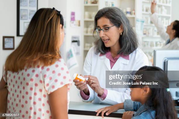 pharmacist talking with customer about prescription bottle - prescription glasses stock pictures, royalty-free photos & images