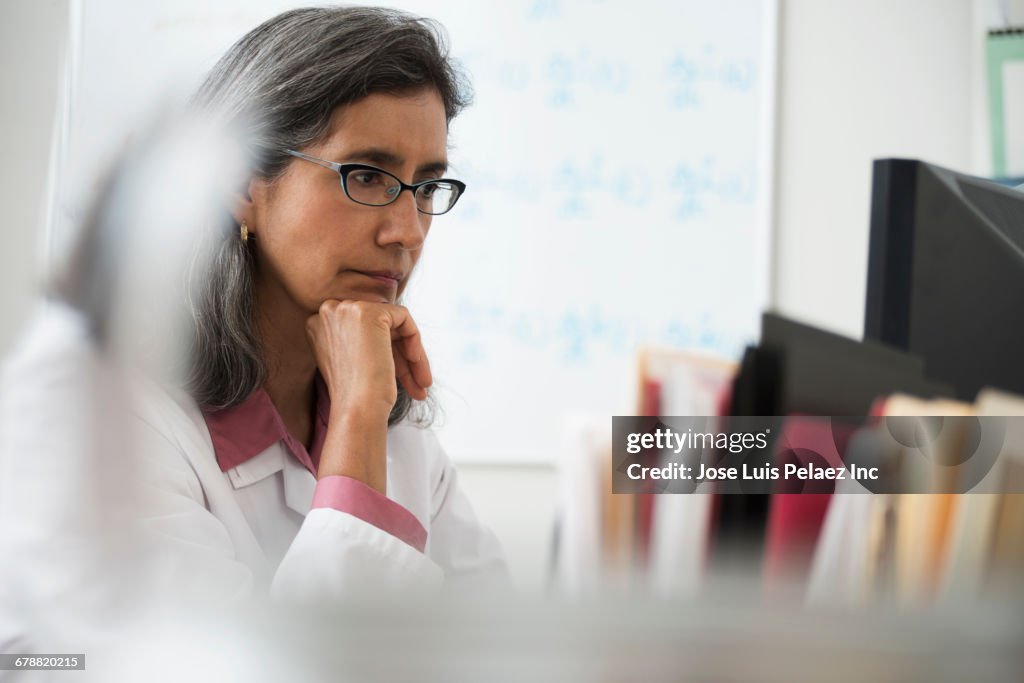 Hispanic doctor using computer at desk