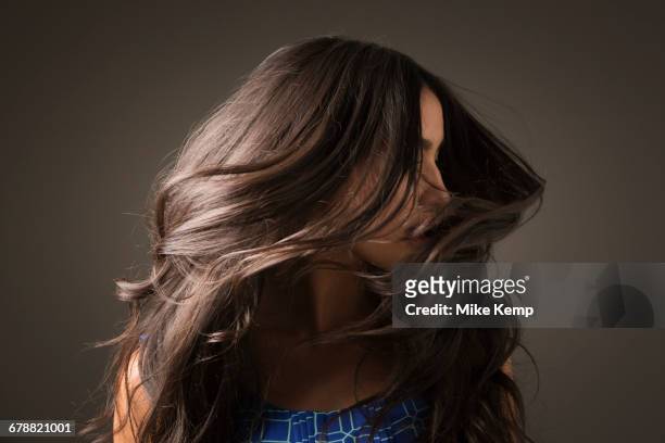 mixed race woman tossing hair - haar stockfoto's en -beelden