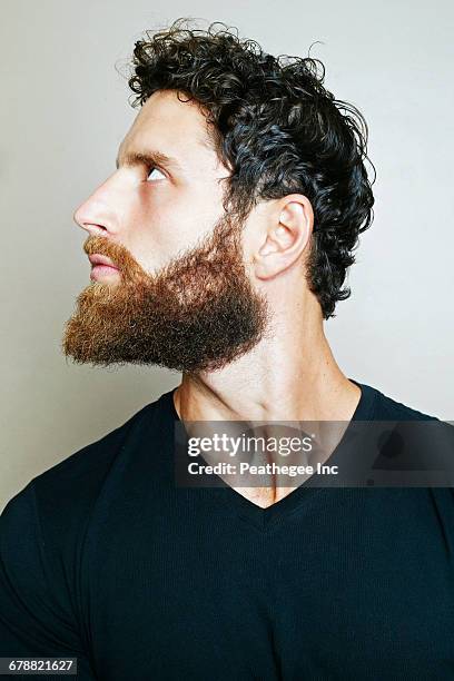 curious caucasian man with beard looking up - bart stock-fotos und bilder