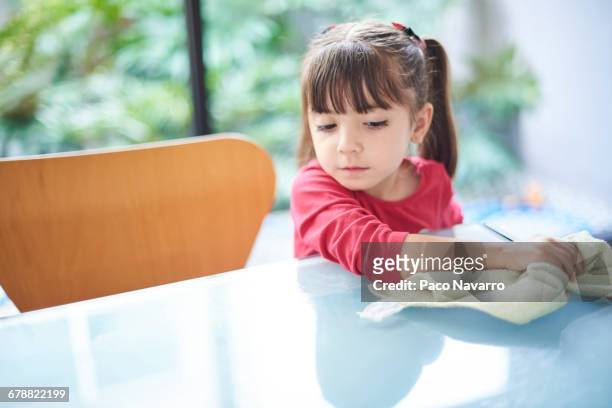 hispanic girl cleaning table with towel - rubbing stock pictures, royalty-free photos & images