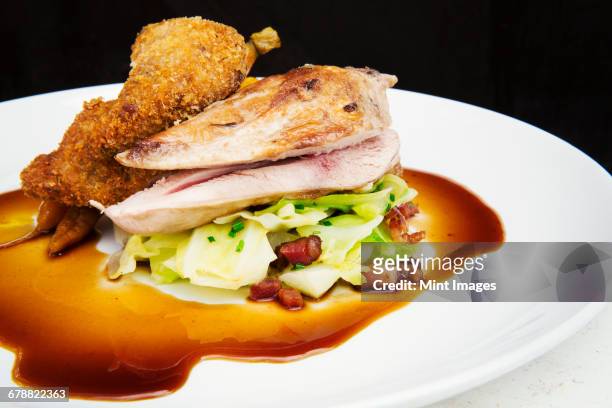 a main course cooked dish, poultry roasted stacked on a pile of vegetables with carrots and a rich brown sauce.  - gastro pub stock pictures, royalty-free photos & images