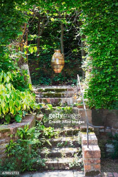 a glazed or amphora in a frame on a terrace at the top of steps, under a pergola.  - anfora fotografías e imágenes de stock