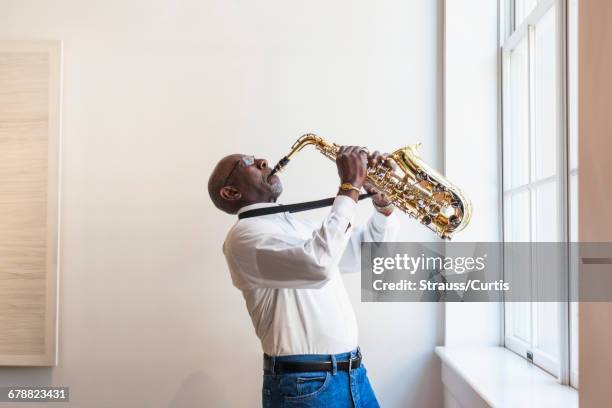 man playing saxophone window - saxofoon stockfoto's en -beelden