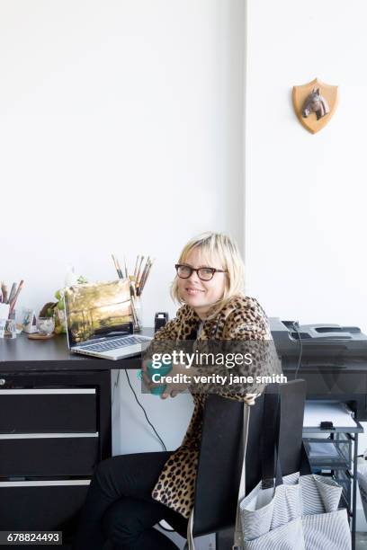 caucasian woman drinking coffee at desk with laptop - leopard print stock pictures, royalty-free photos & images