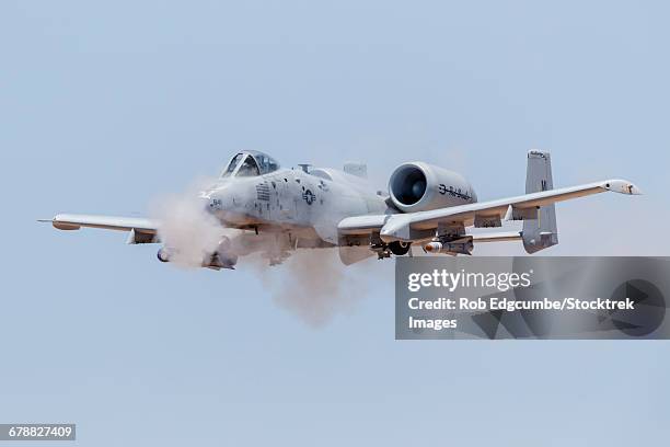 a u.s. air force a-10 thunderbolt ii fires its 30mm gun at a strafe target. - gatling gun stock pictures, royalty-free photos & images
