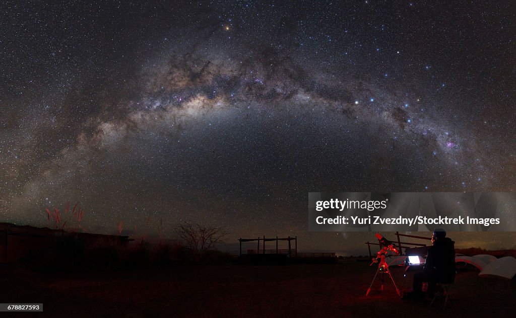 Astronomer with a telescope looking at the Milky Way in the Atacama Desert, Chile.