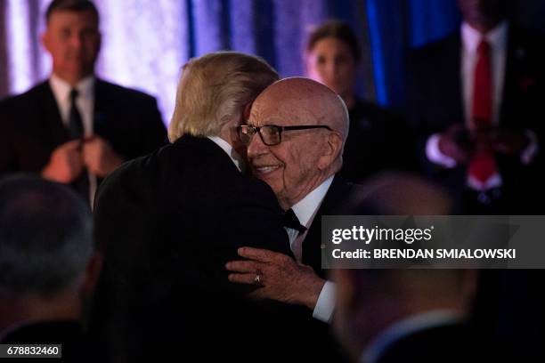 President Donald Trump is embraced by Rupert Murdoch, Executive Chairman of News Corp, during a dinner to commemorate the 75th anniversary of the...