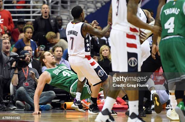 Kelly Olynyk of the Boston Celtics is knocked to the floor by Kelly Oubre Jr. #12 of the Washington Wizards in the second quarter during Game Three...