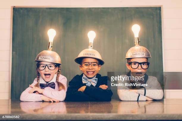 three young nerds with thinking caps - kids creativity imagens e fotografias de stock