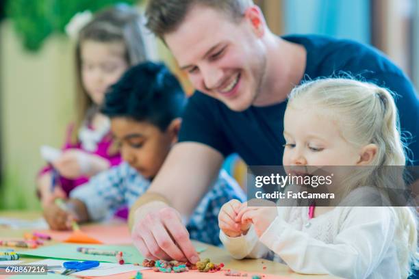 ayuda del maestro - nursery school child fotografías e imágenes de stock