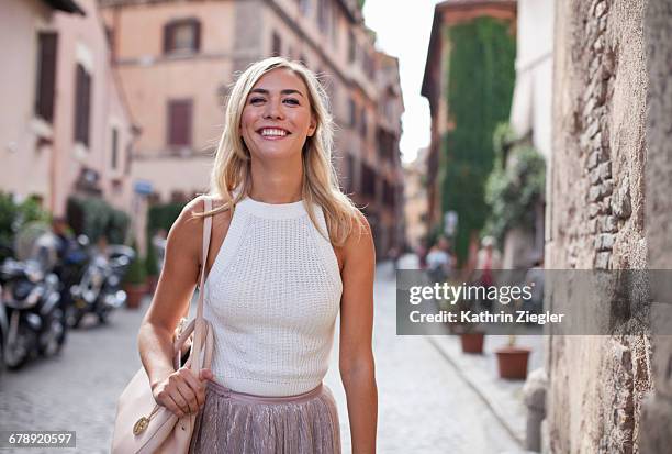 beautiful woman walking on cobblestone street - skirt stock pictures, royalty-free photos & images