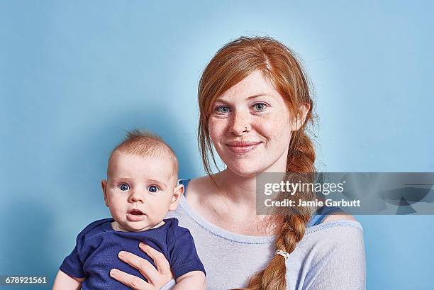 british redheaded female and he infant son - family on coloured background stock pictures, royalty-free photos & images