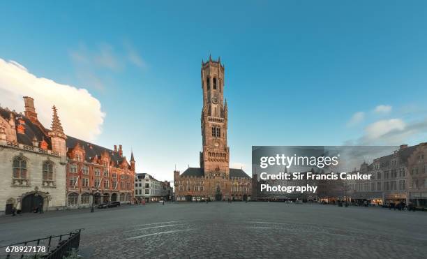 medieval market square ("grote markt" or "grand place") with belfry, in the historic center of bruges, flanders, belgium, a unesco heritage site - bruge stock-fotos und bilder