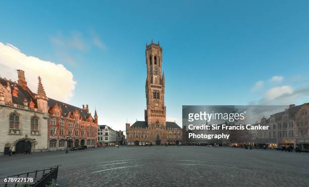 medieval market square ("grote markt" or "grand place") with belfry, in the historic center of bruges, flanders, belgium, a unesco heritage site - bruges stockfoto's en -beelden