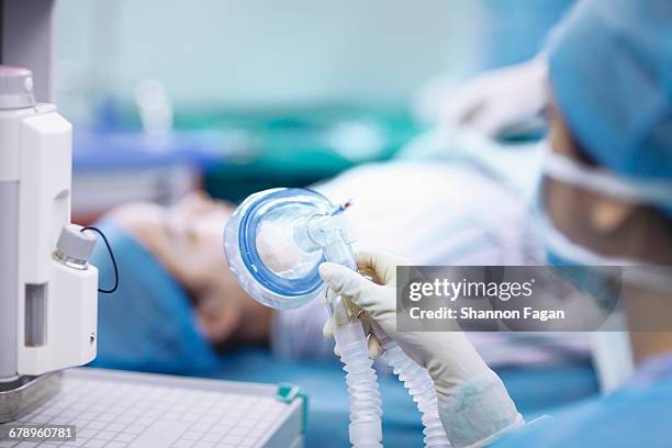 nurse holding anesthesia mask in operating room - verdovingsmiddel stockfoto's en -beelden