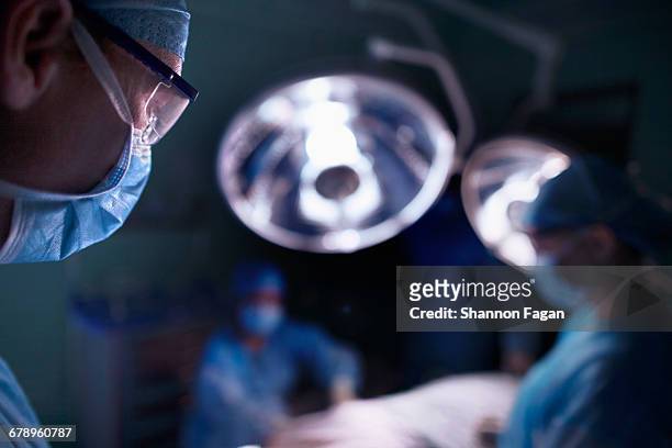 doctor looking at surgical table in operating room - operatiekamer stockfoto's en -beelden