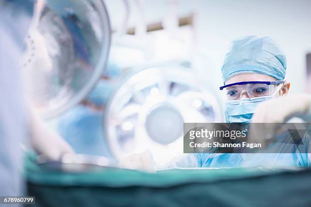 surgeon performing operation in operating room - surgery stock pictures, royalty-free photos & images