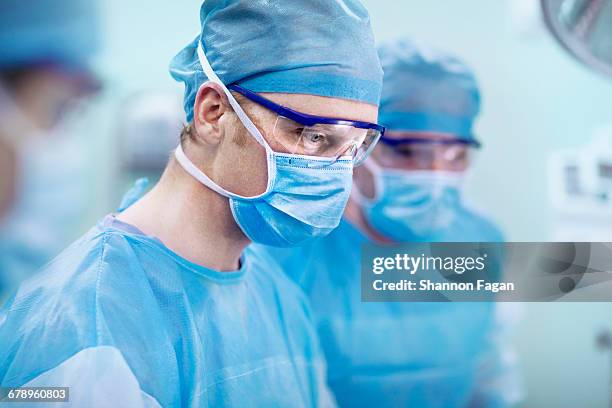 doctor looking at surgical table in operating room - 外科醫生 個照片及圖片檔