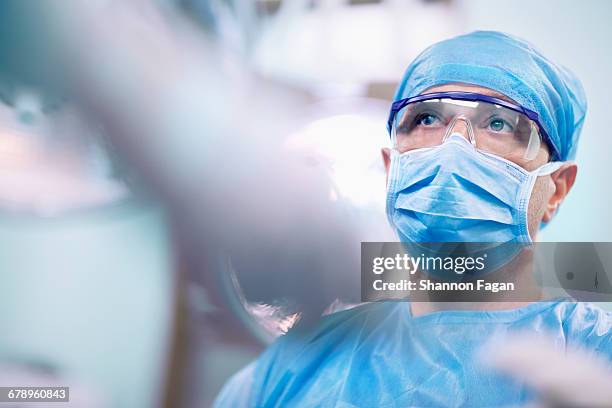 nurse giving tools to surgeon in operating room - operationssaal stock-fotos und bilder