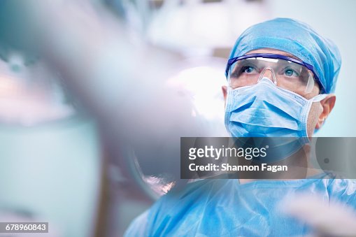Nurse giving tools to surgeon in operating room