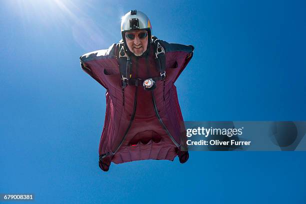 this wingsuit pilot is diving down with high speed - skydiving pov stock pictures, royalty-free photos & images