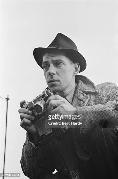 Picture Post photographer Bert Hardy on an assignment, February 1941. He is using a Contax II 35 mm rangefinder camera. Original Publication: Picture...