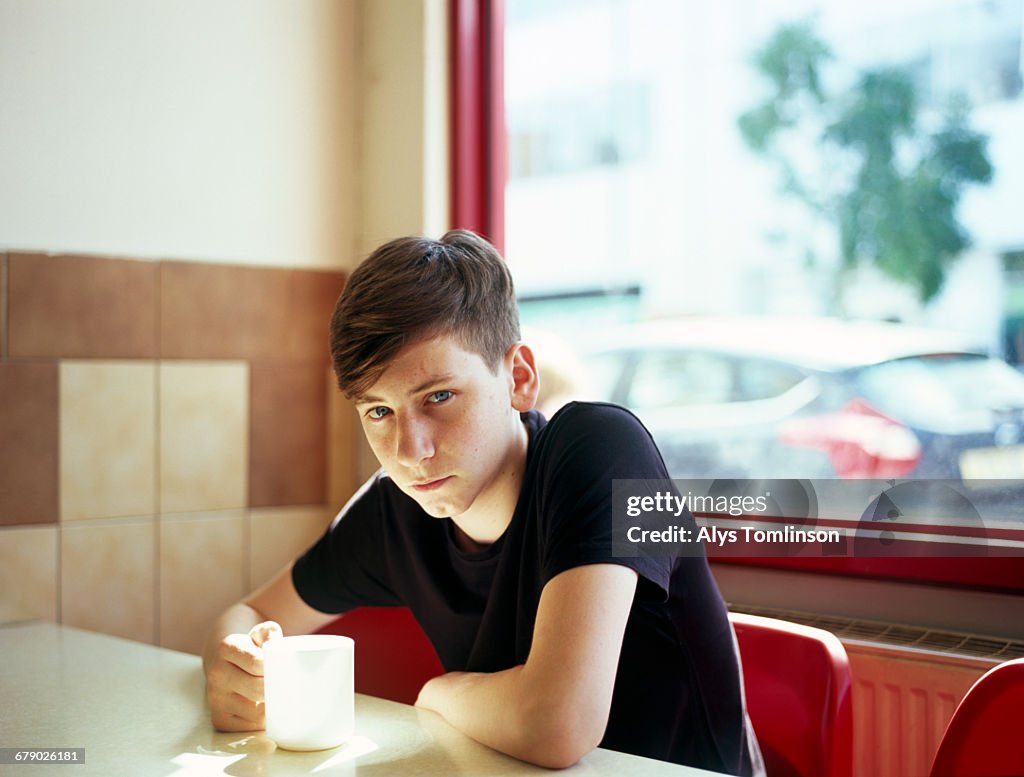 Portrait of teenage boy sitting in a cafe