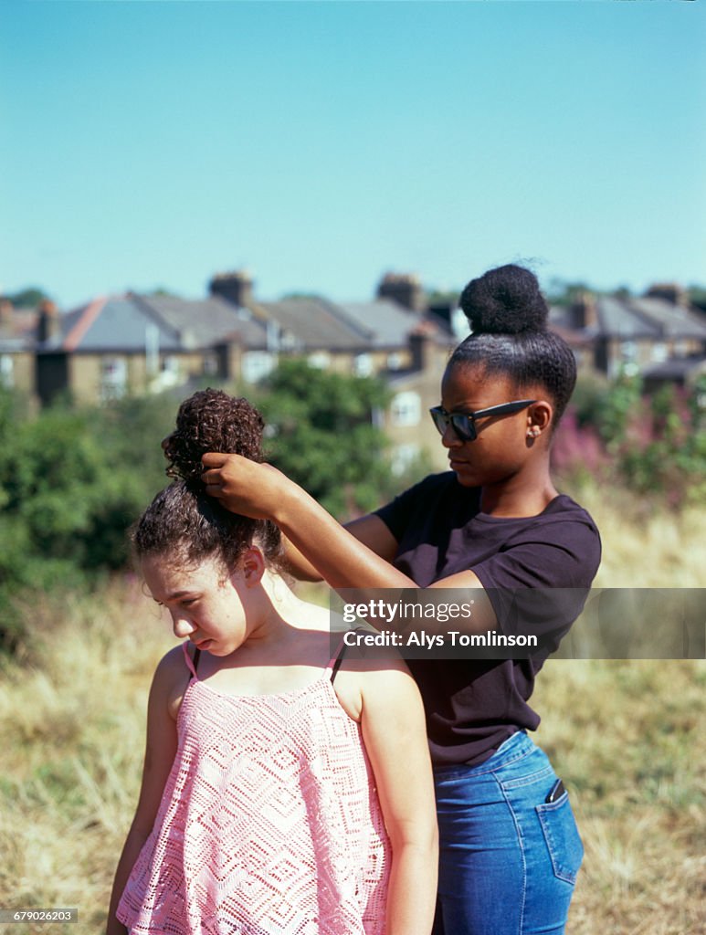 Teenage girl playing with her friend's hair