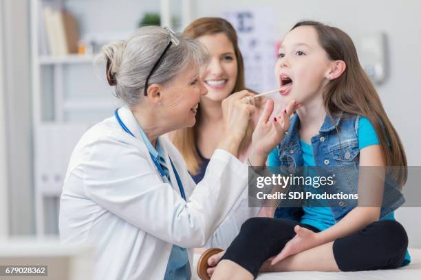 pediatrician checks young patient's throat - tongue depressor stock pictures, royalty-free photos & images