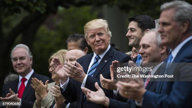 President Donald Trump looks to House Speaker Paul Ryan of Wis., and other House congressmen in the Rose Garden after the House pushed through a...