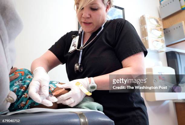 Lydia Fulton, LPN, administers the MMR vaccine to a child at Children's Primary Care Clinic in Minneapolis, MN, Friday April 28, 2017. Children's has...