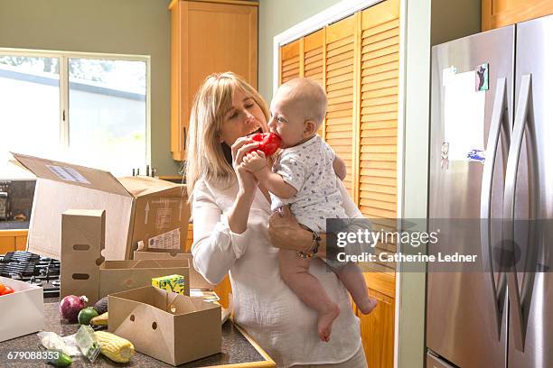 mother and baby with home delivered food - trying new food stock pictures, royalty-free photos & images