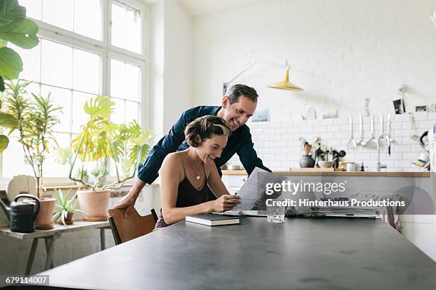 mature couple reading document - mann am tisch mit papier stock-fotos und bilder